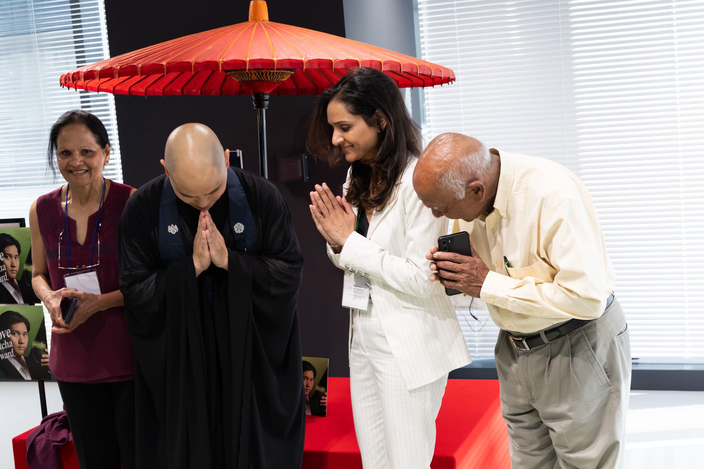 A monk and attendees bowing with hands together after zazen