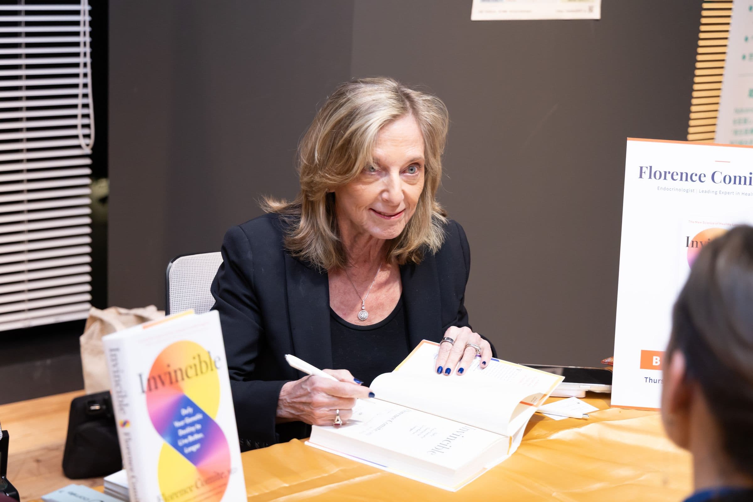 Florence Comite signing a copy of her book Invincible