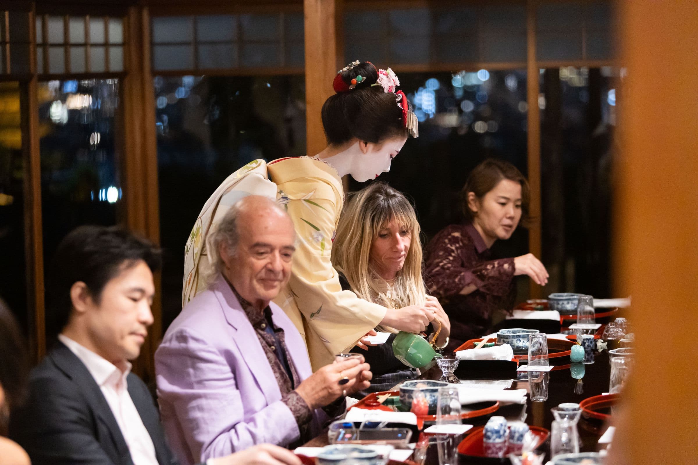 Guests at a long table during dinner in Kyoto