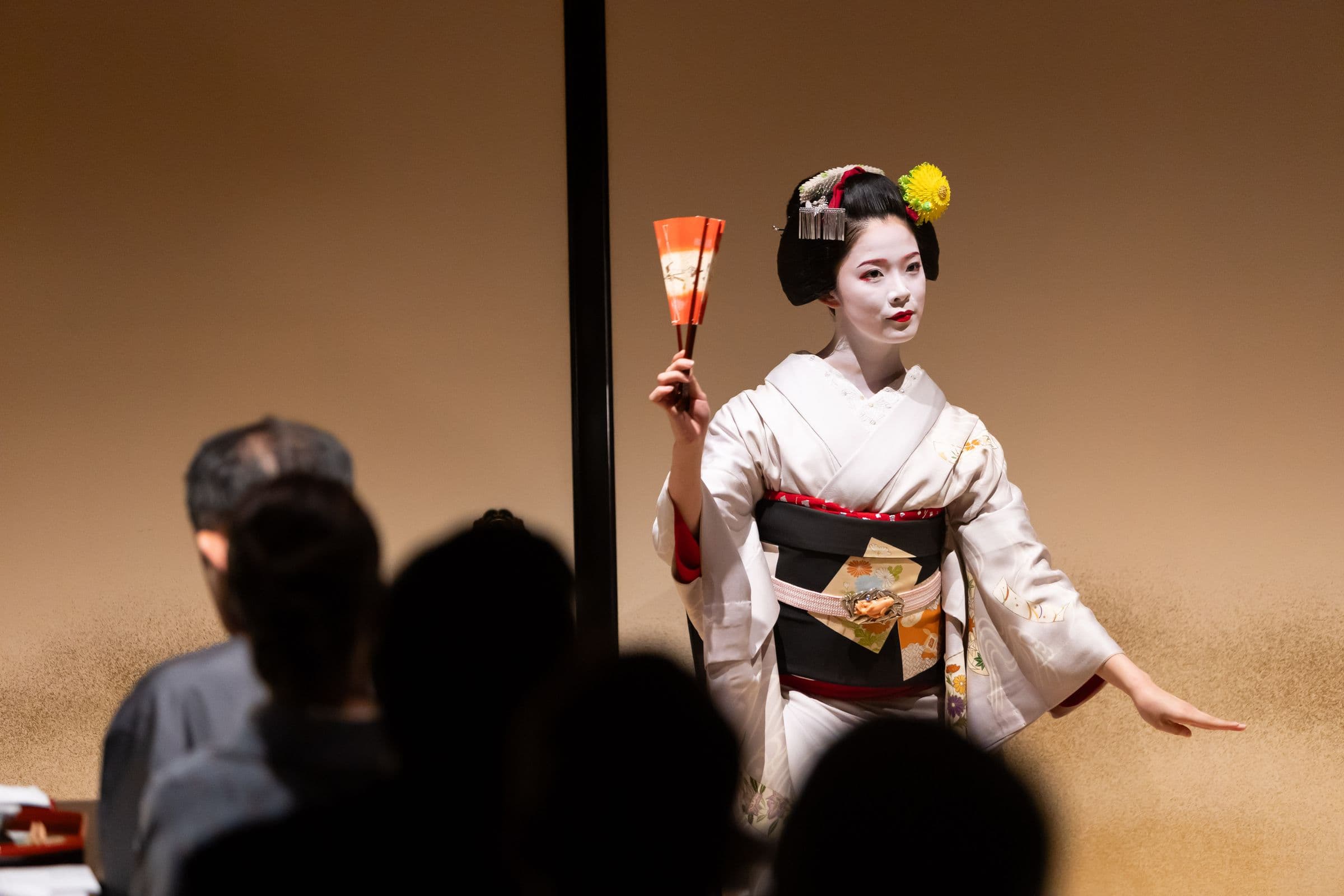A maiko dancing with a fan